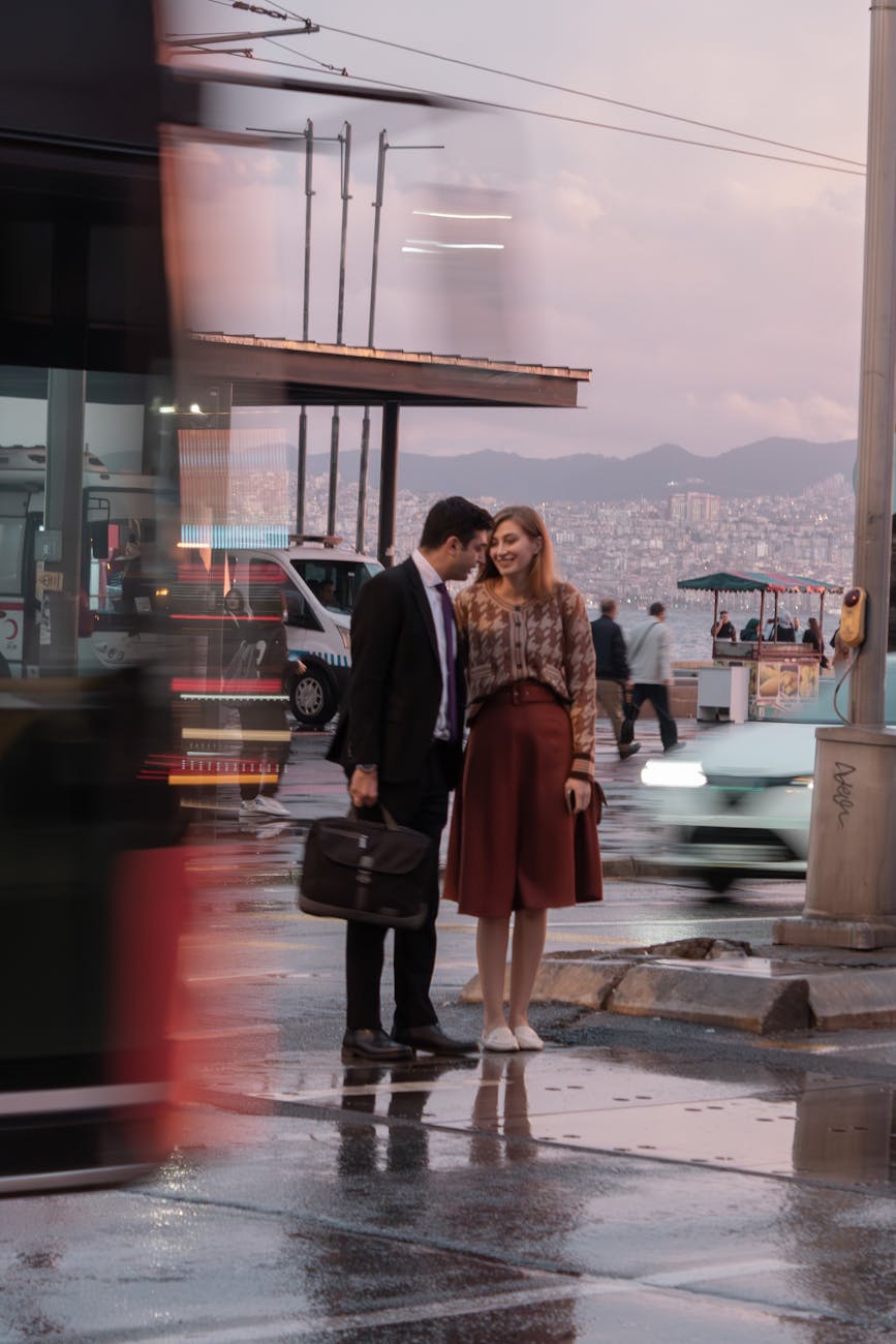 smiling man in suit and woman in skirt in city