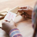 hands holding thank you note and envelope