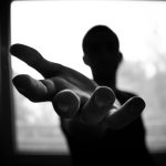 man s hand in shallow focus and grayscale photography