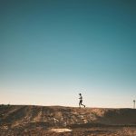 photo of person running on dirt road