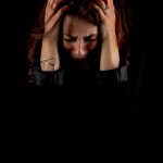 woman in emotional distress holding head