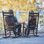 romantic couple relaxing on wooden rocking chairs