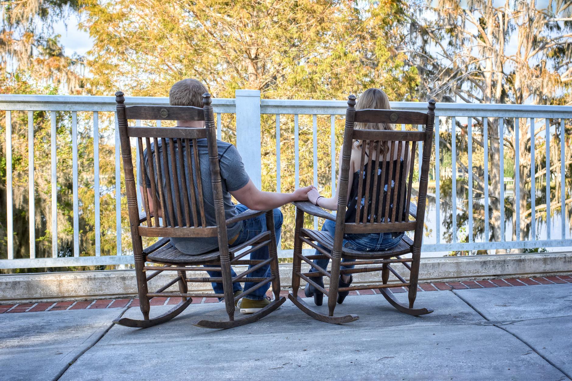 romantic couple relaxing on wooden rocking chairs