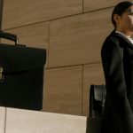 man in black suit jacket standing beside black chair