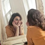 photo of woman looking at the mirror