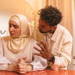 furious man talking with unhappy woman in hijab
