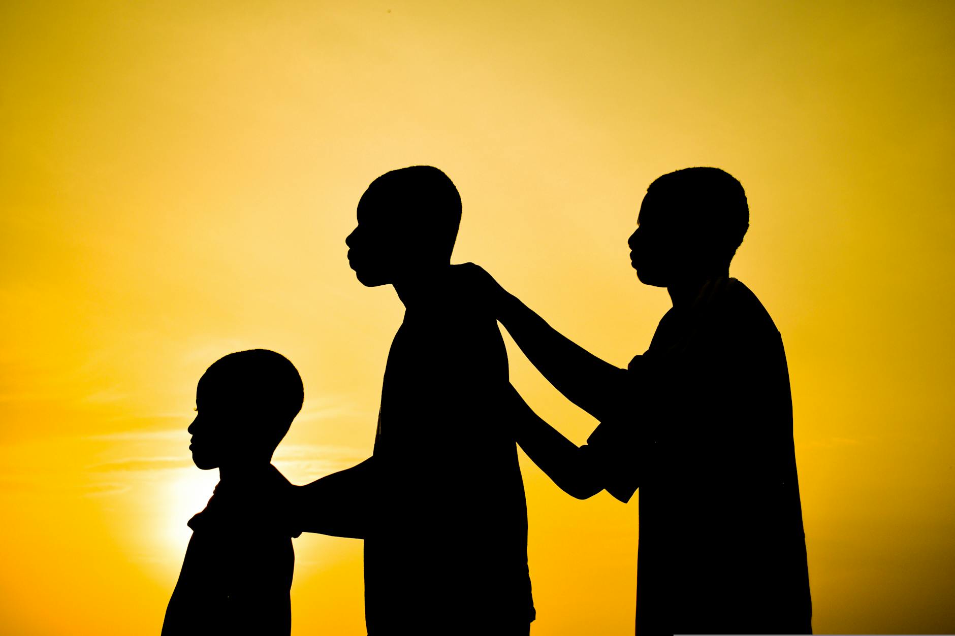 silhouette of boys standing together