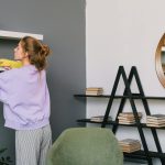 woman wearing gloves cleaning the shelves