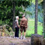 two people standing in forest
