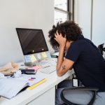 frustrated woman sitting by desk