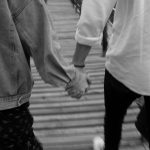 back view of couple holding hands in black and white