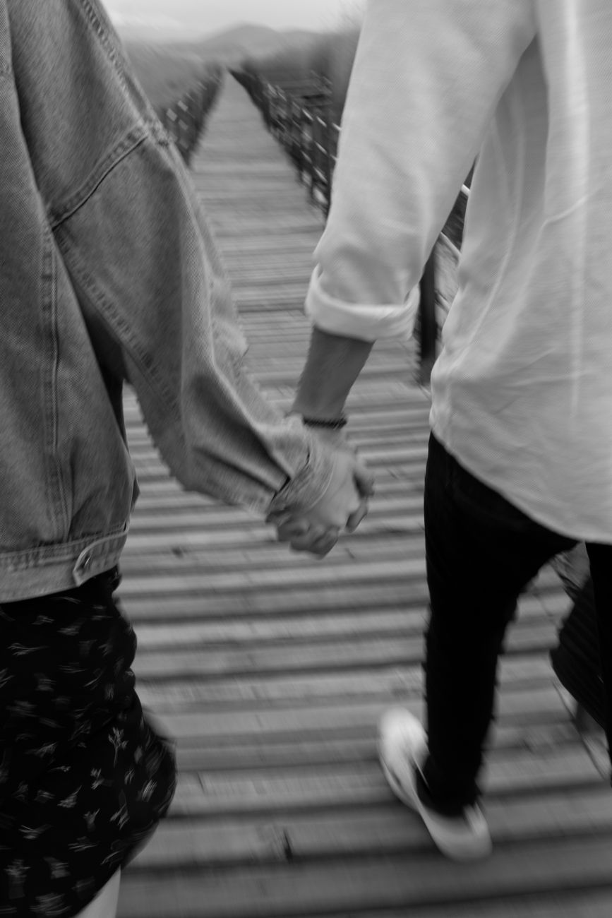 back view of couple holding hands in black and white