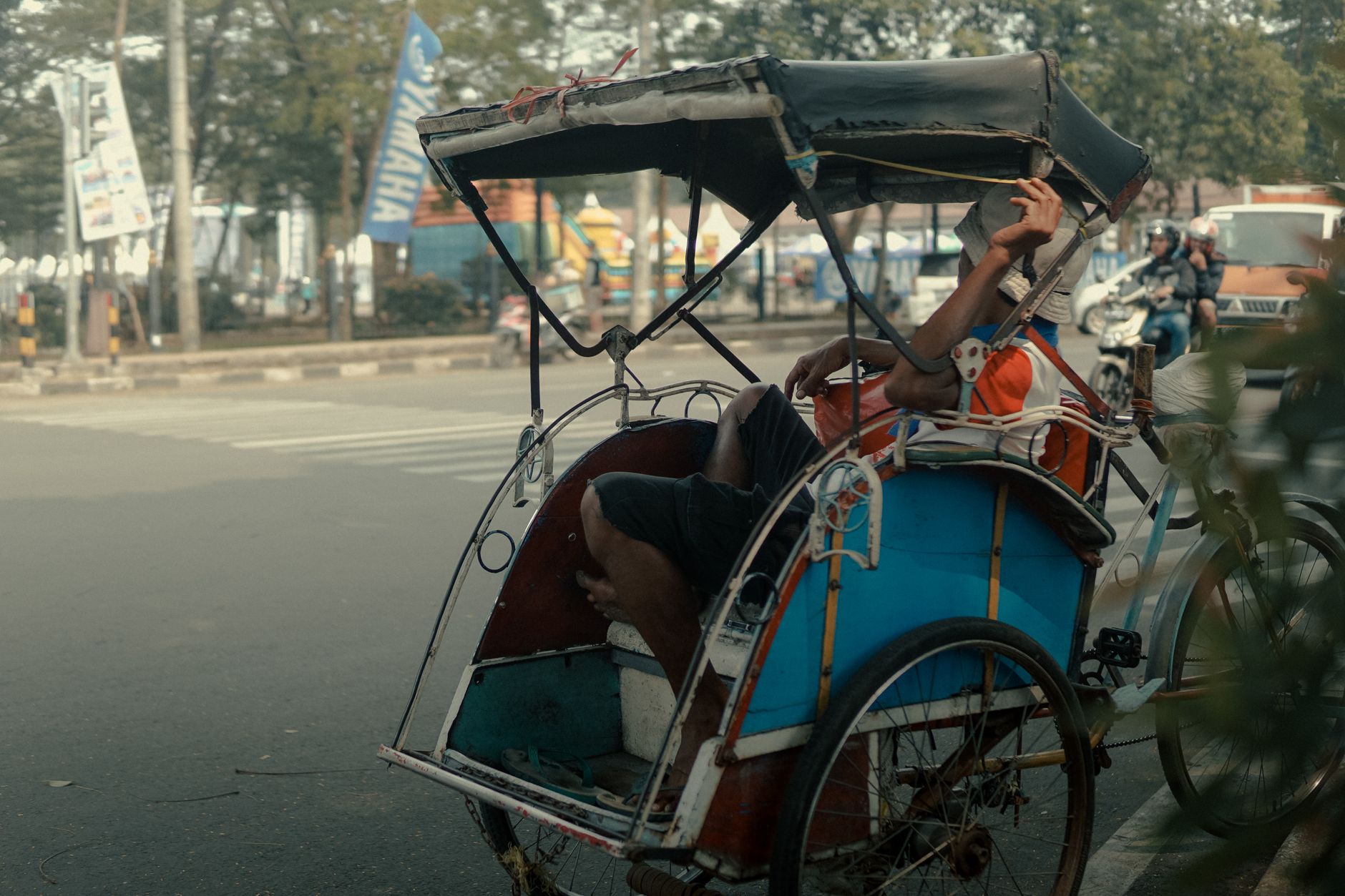 man lying down on rickshaw