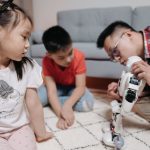 father controlling the white robot he is holding in front of his kids